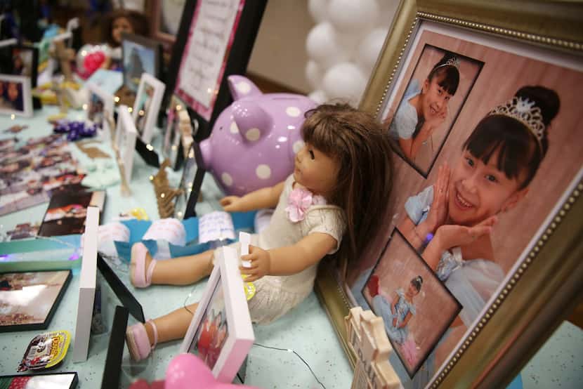 Pictures and mementos line a table at a memorial service and viewing for 12-year-old Linda...