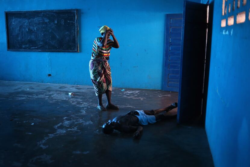  Omu Fereneh  stands over her husband Ibrahim after he staggered and fell, knocking him...