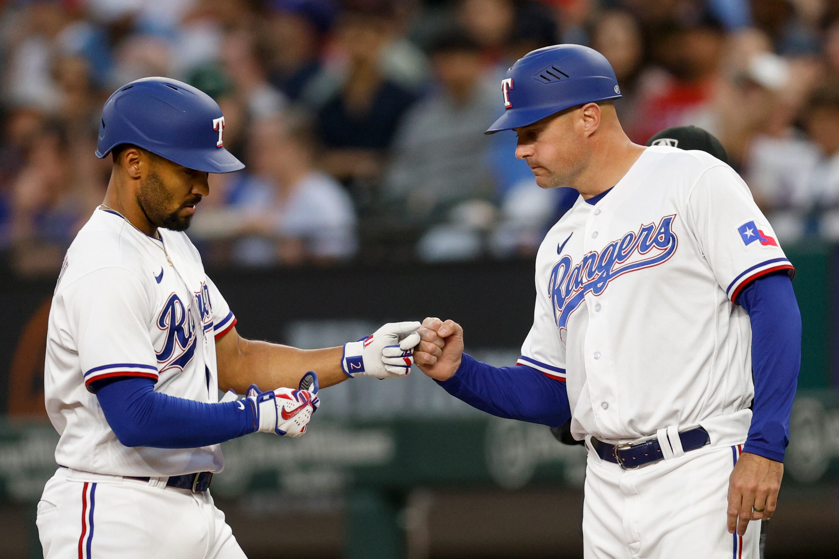 Texas Rangers second baseman Marcus Semien (2) celebrates a single with first base coach...