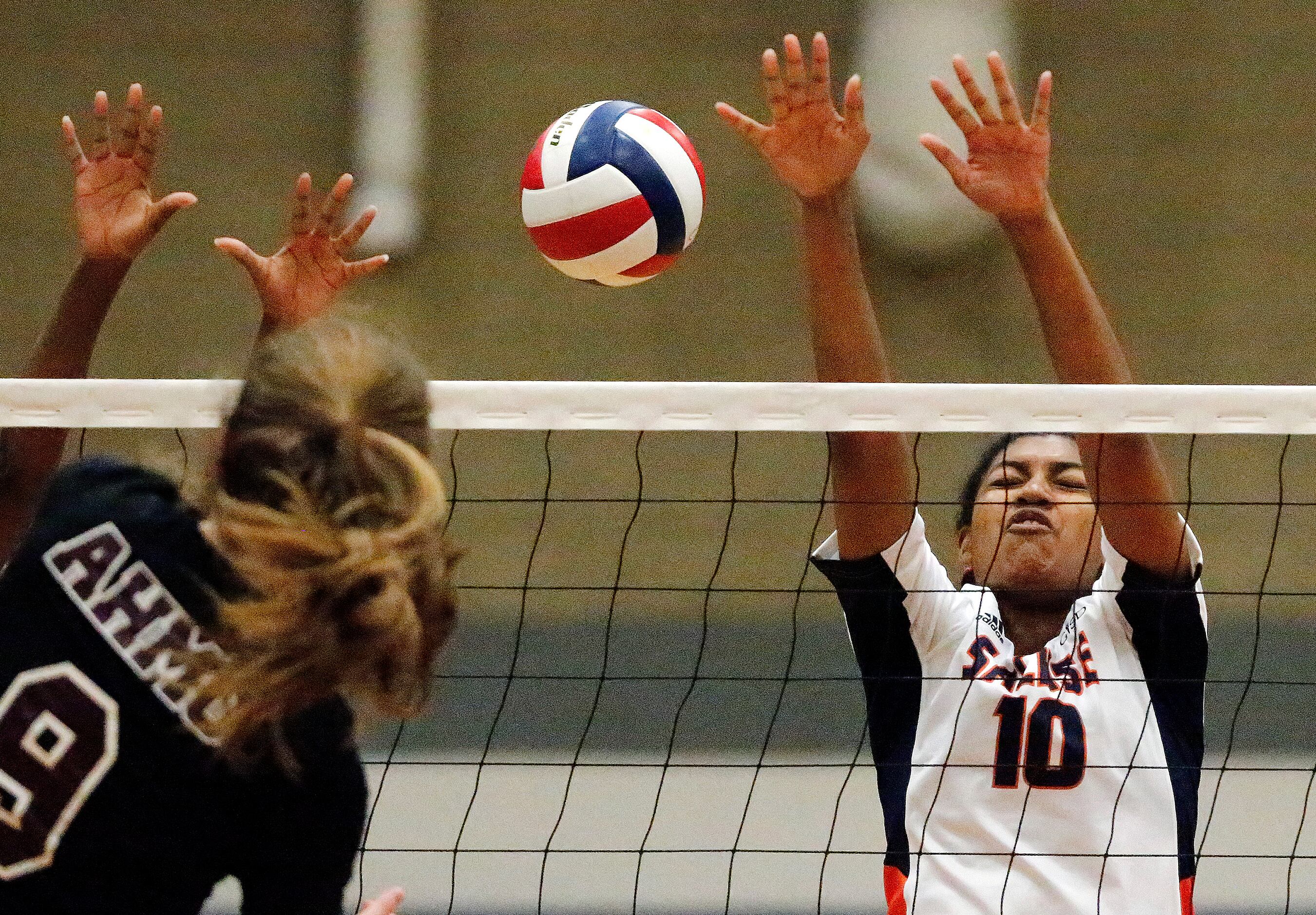 Wylie High School outside hitter Miya Cain (10) attempts a block on a hit by Wylie High...