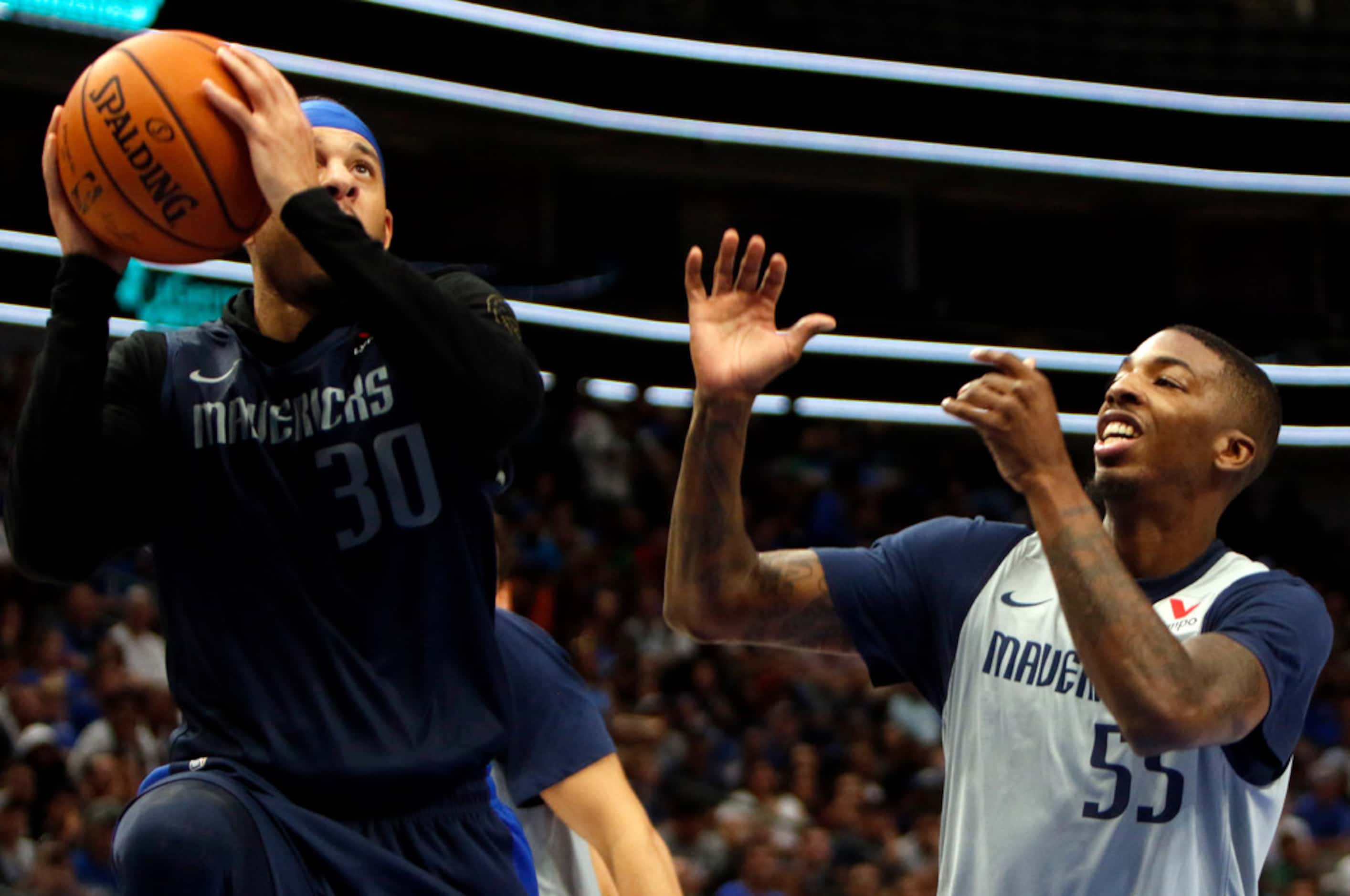 Dallas Mavericks guard Seth Curry (30) drives to the basket as guard Delon Wright (55)...