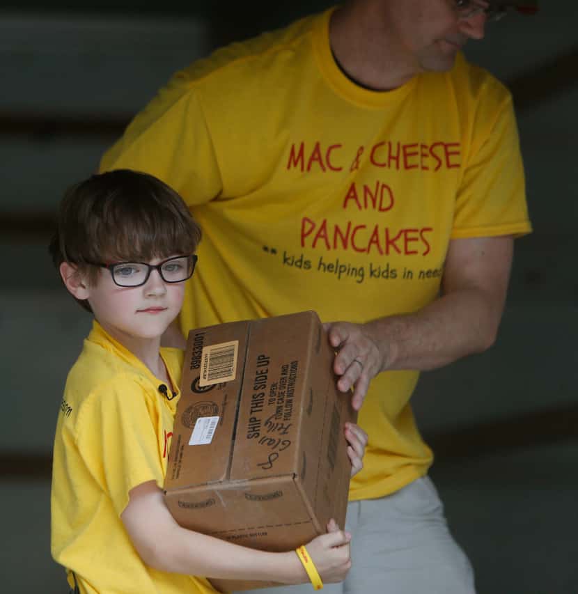 Kaden Newton, 7, and his dad, Keegan Newton, unloaded kid-friendly food items at The...