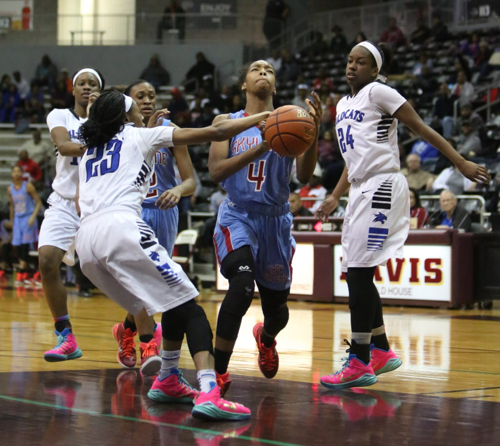 Skyline guard Raven Johnson (4) drives to the hoop against Dekaney's Jasmine Smith (left)...