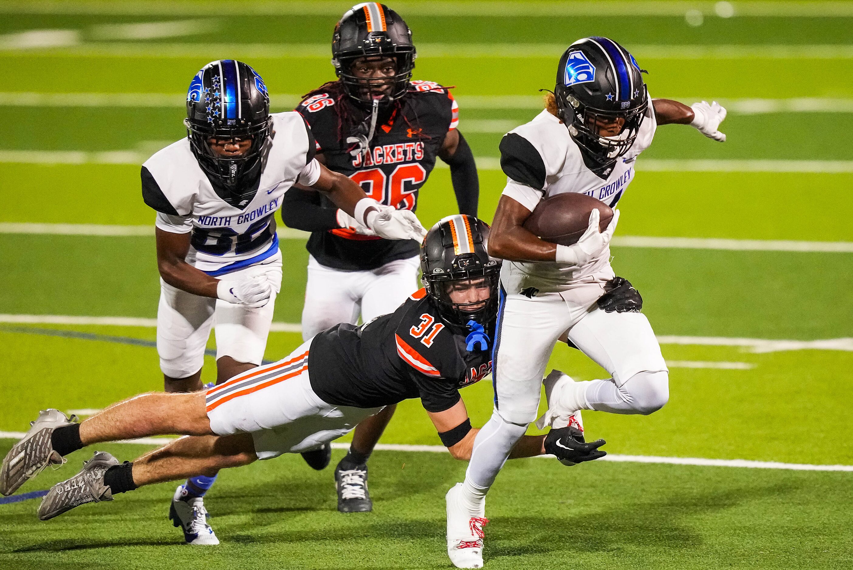 North Crowley wide receiver Malachi Johnson (81) is brought down by Rockwall defensive back...