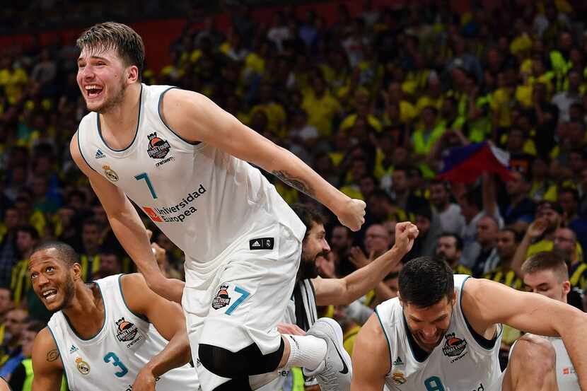 Real Madrid's Slovenian Luka Doncic (7) jumps over the barrier as the team celebrates their...