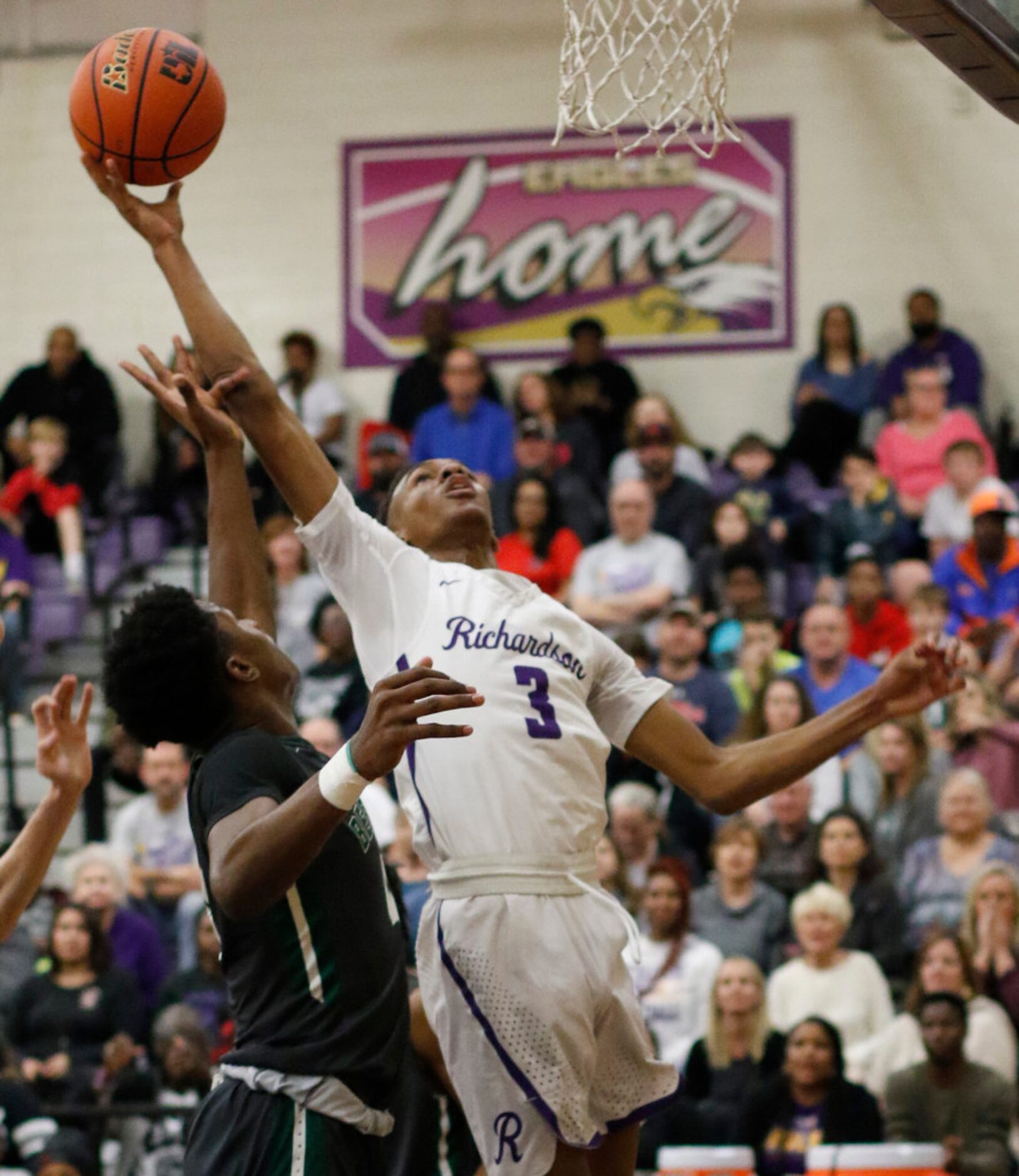 Richardson's Rylan Griffen (3) drives hard to the basket against the defense of Richardson...