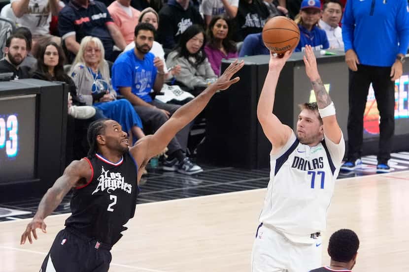 Dallas Mavericks guard Luka Doncic, right, shoots as Los Angeles Clippers forward Kawhi...