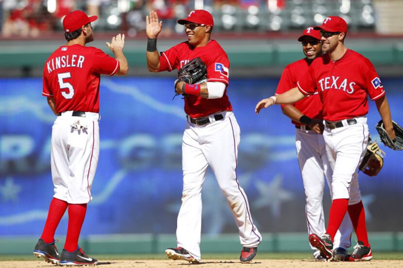 Texas Rangers center fielder Engel Beltre (43, center) is congratulated by teammate Ian...