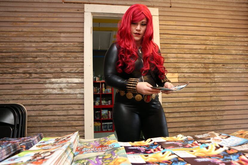 Geline Spinks, dressed as Marvel comic's Black Widow, selects comics at annual Free Comic...