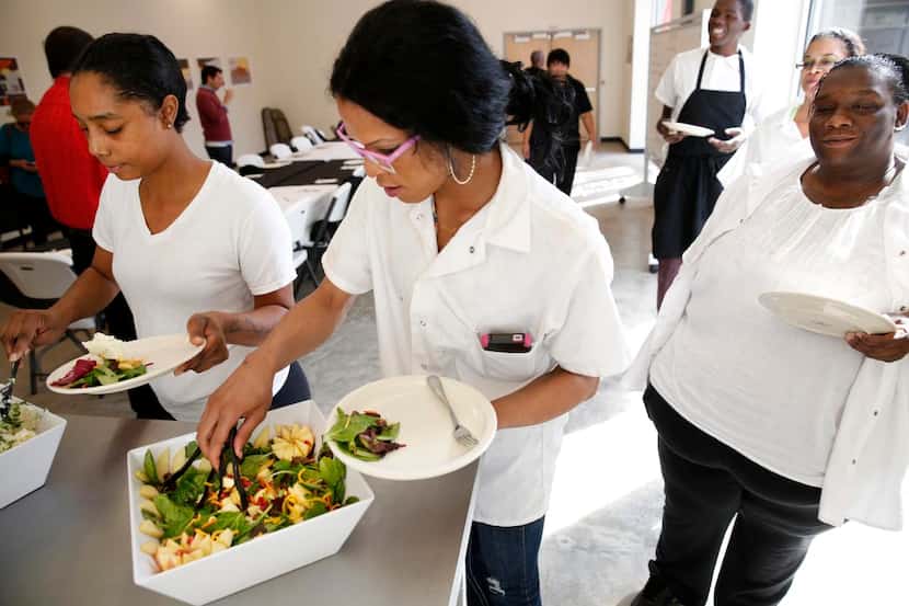 
From left: Stephanie Hawkins, Rodriguez and Teara Taylor serve themselves from dishes they...