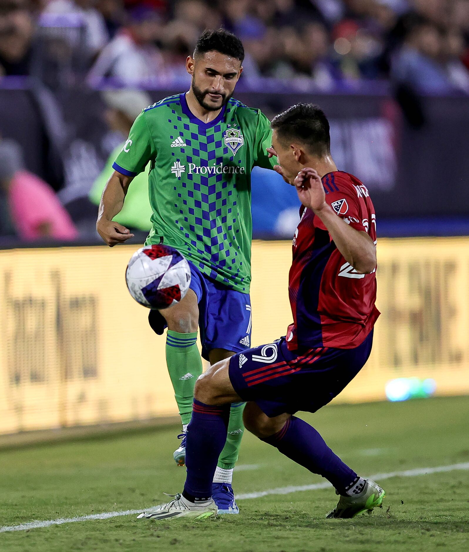 FC Dallas defender Sam Junqua (right) goes for a loose ball against Seattle midfielder...