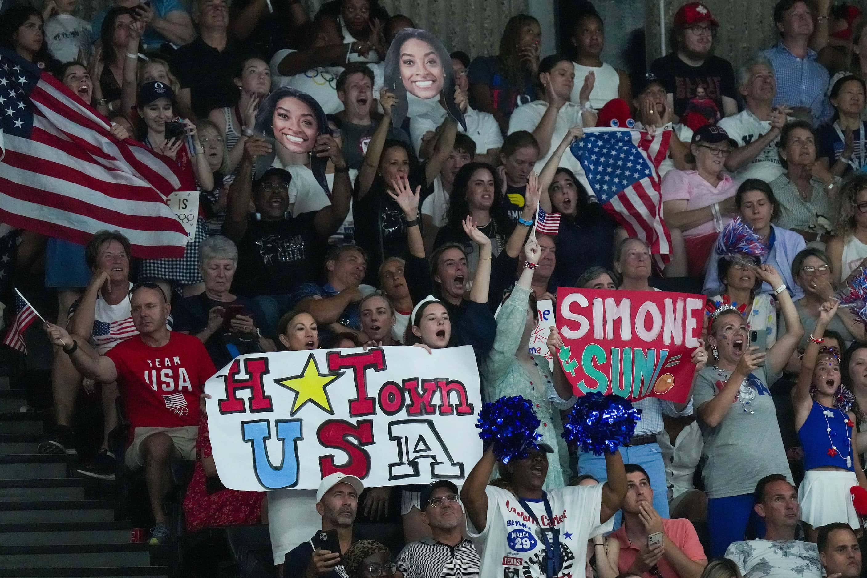 Fans cheer as Simone Biles of the United States prepares to compete on the floor during the...