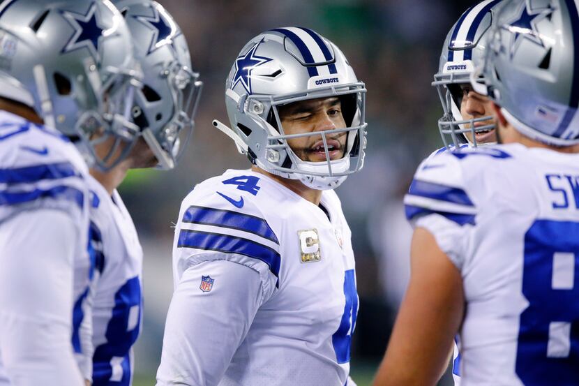 Dallas Cowboys quarterback Dak Prescott (4) winks at his teammates as they huddle up during...