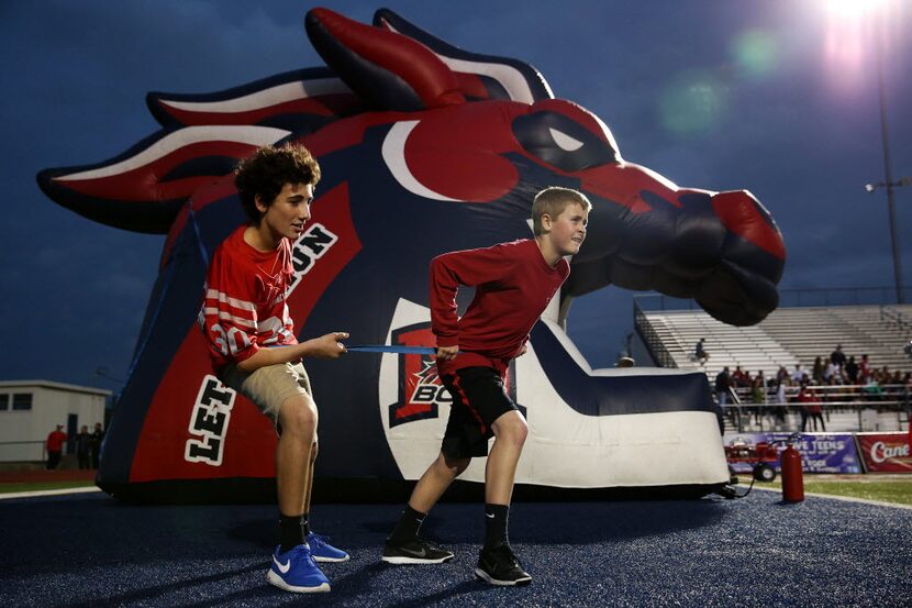 Matthew Nori (left), 14, and Trey Hutto, 13, fights the wind holding the McKinney Boyd...