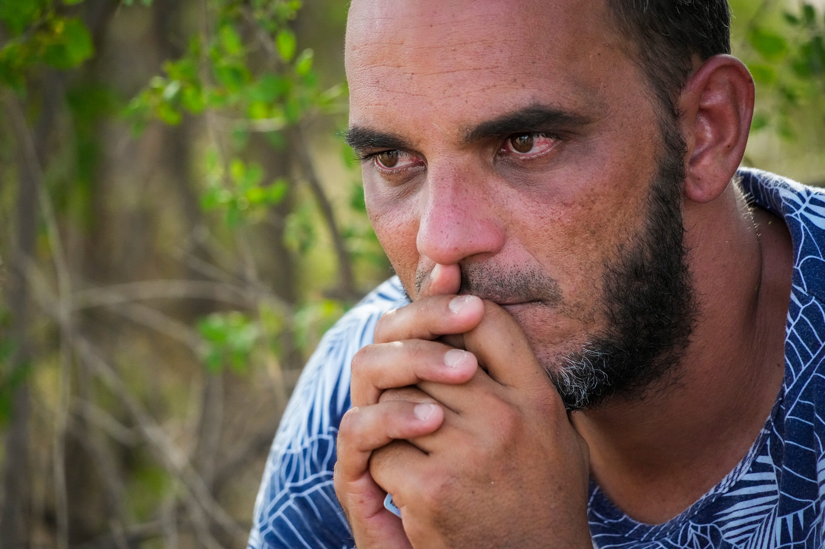 Aramis, a migrant from Nicaragua, rests under a mesquite tree on Wednesday, Aug. 17, 2022,...