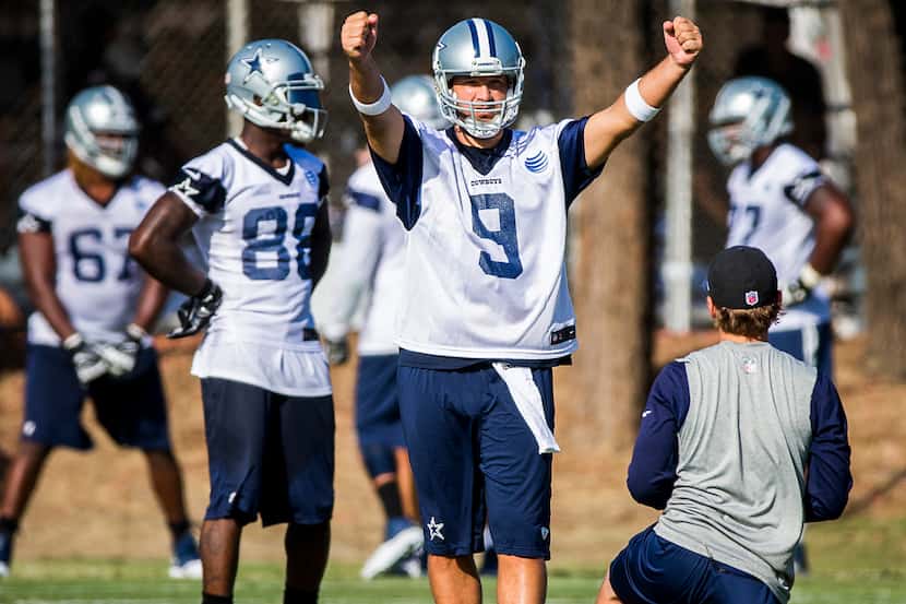 Dallas Cowboys quarterback Tony Romo (9) motions to his teammates during the first practice...