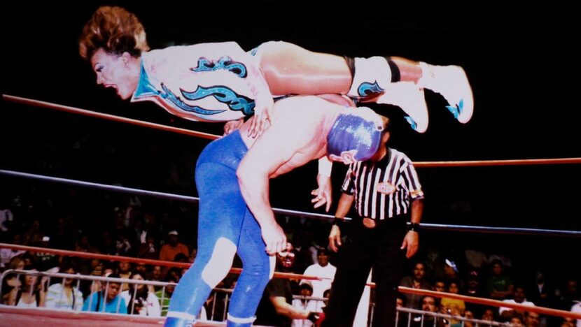 Mexican wrestler Cassandro maneuvers an opponent in the ring during one of his matches.