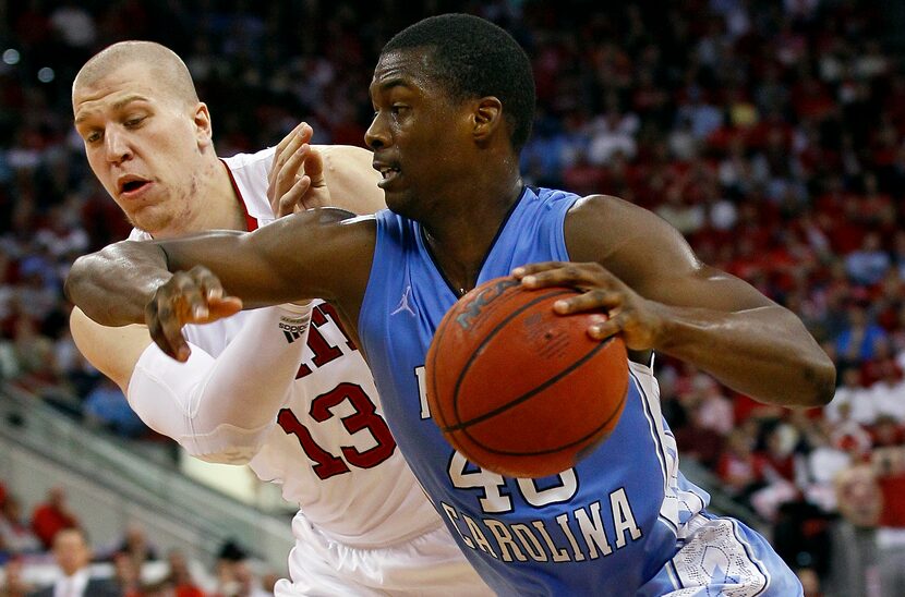 North Carolina's Harrison Barnes is guarded by North Carolina State's Thomas de Thaey (13)...