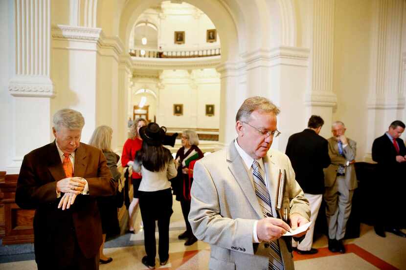 
Lobbyist Robert Culley (center) took notes while waiting with others for legislators...