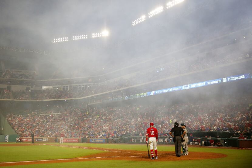 Texas Rangers left fielder Ryan Rua (16) waits to bat as the smoke from the fireworks...