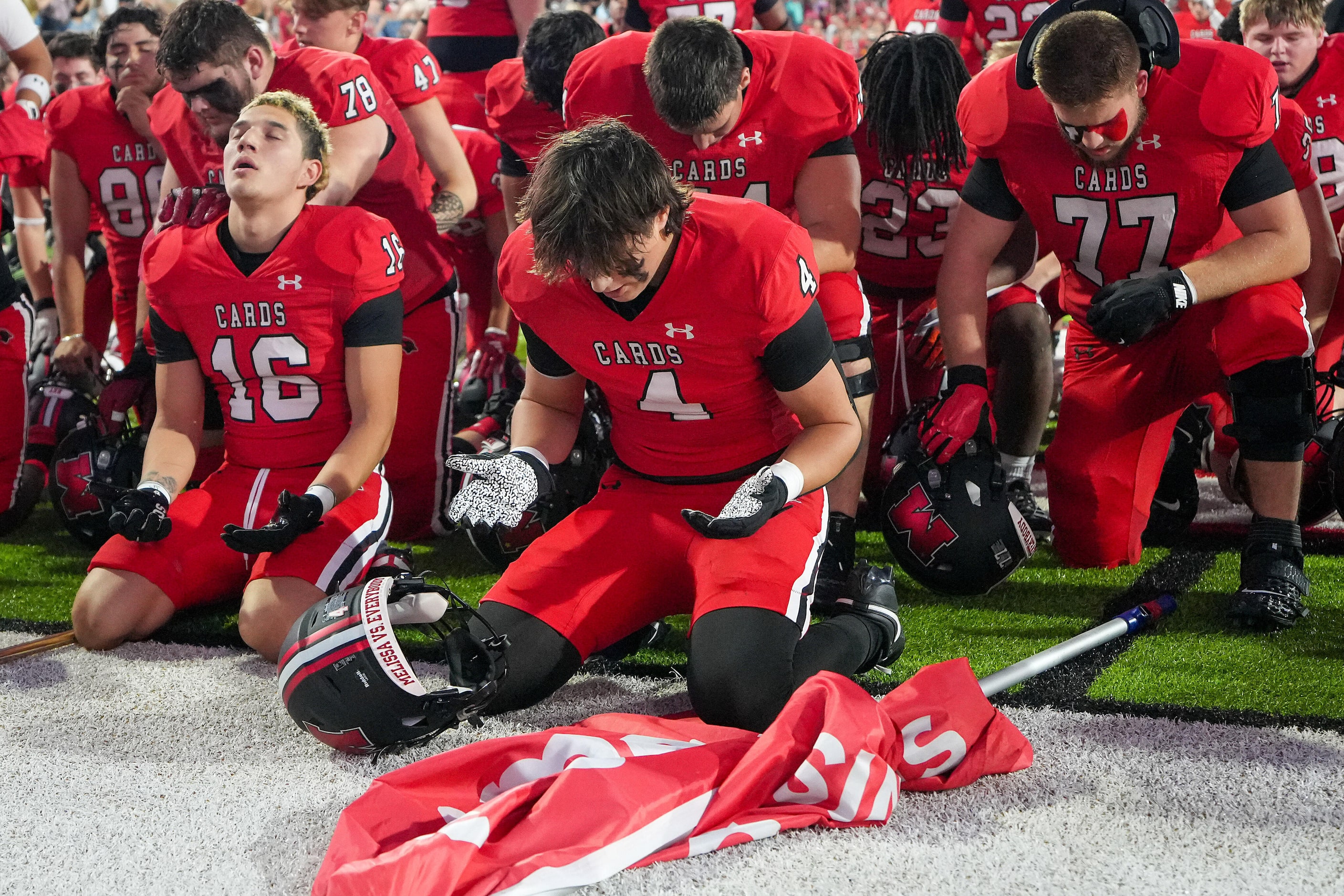 Melissa’s Max Corbin (4) and Antonio Sparks (16) kneel in prayer with before a District 4-5A...