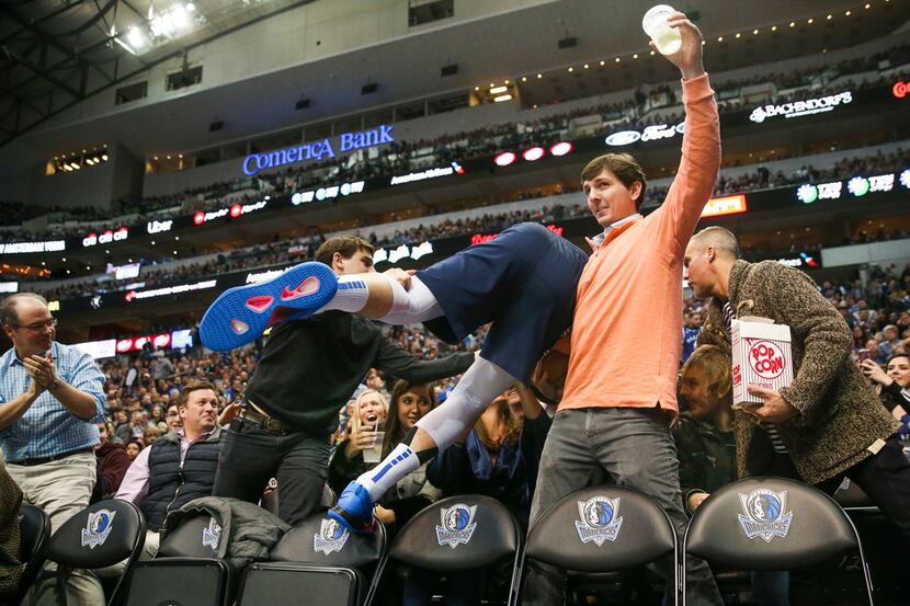 Dallas Mavericks forward Luka Doncic (77) collides into fans during an NBA basketball game...