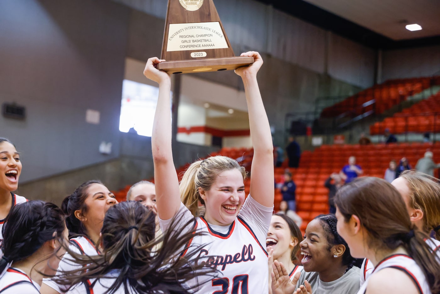 Coppell senior guard Julianna LaMendola (20) raises the team’s trophy above her teammates...