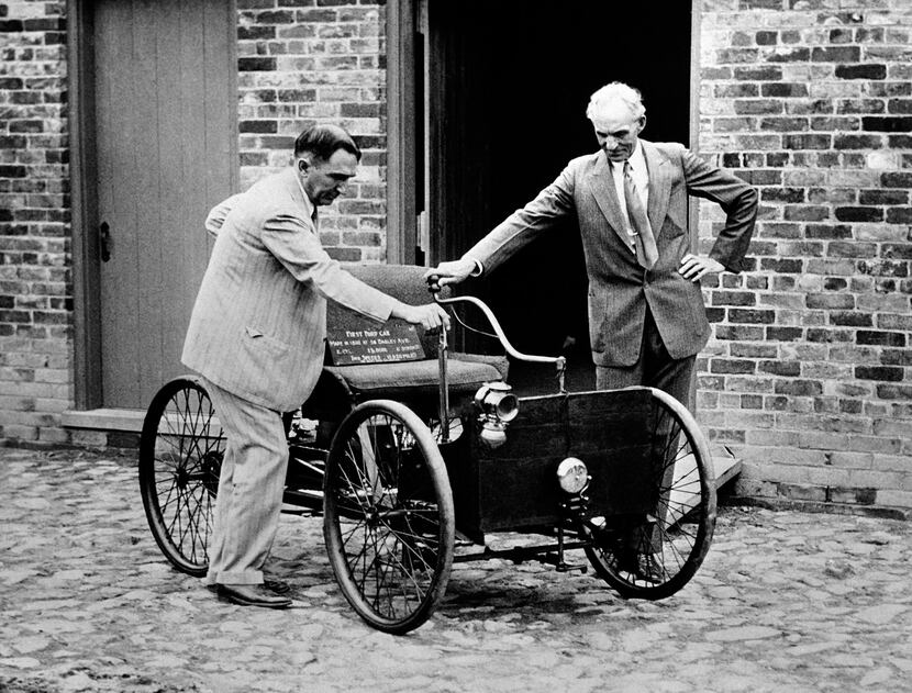 FILE - In this Dec. 10, 1936 file photo, Henry Ford, right, stands with his first car built...