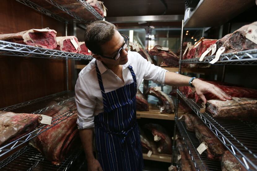 Chef John Tesar examines dry-aged prime cuts in the meat locker at the Knife restaurant in...