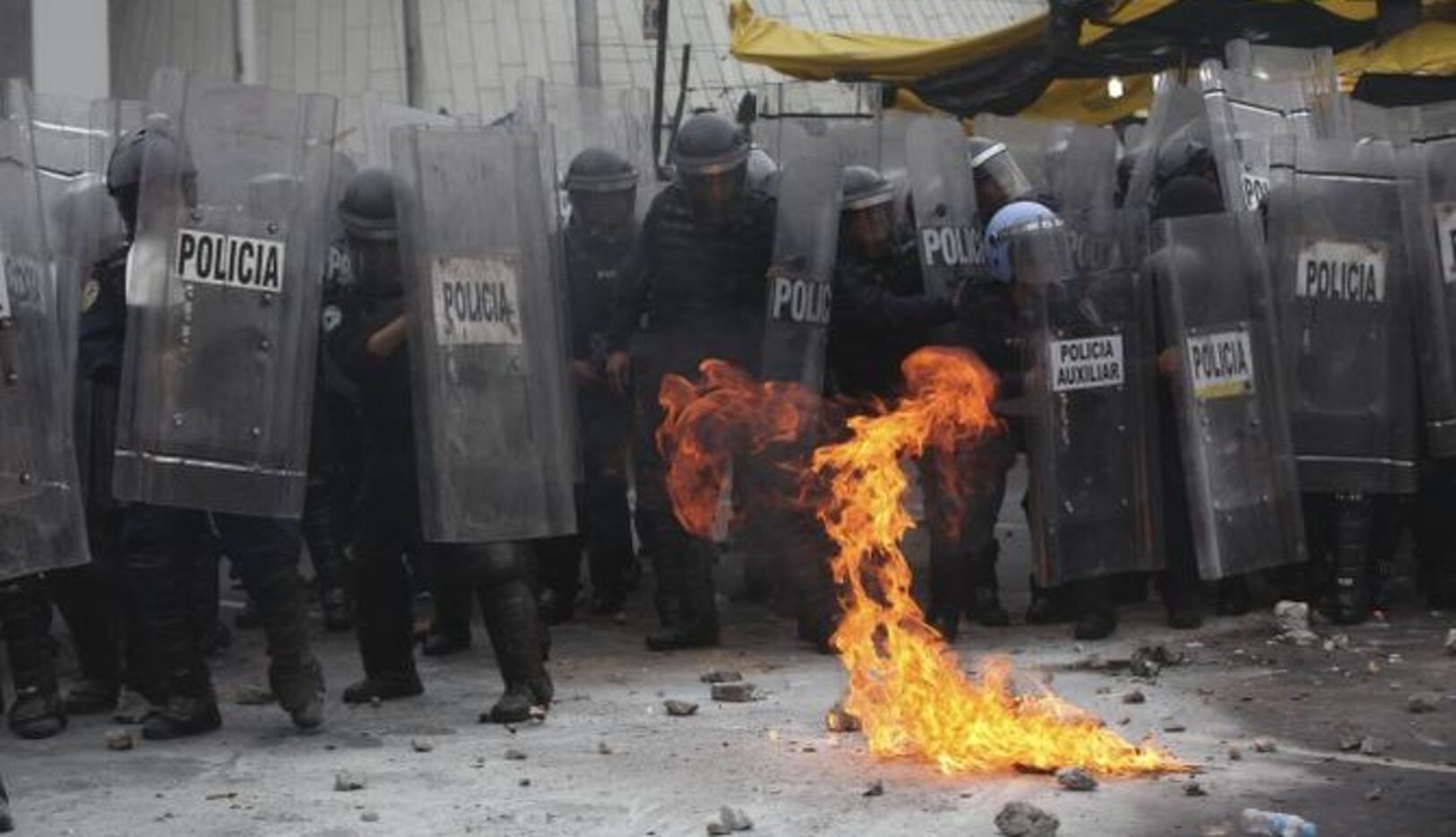 Policías se repliegan luego que manifestantes lanzaron un coctel molotov cerca del...