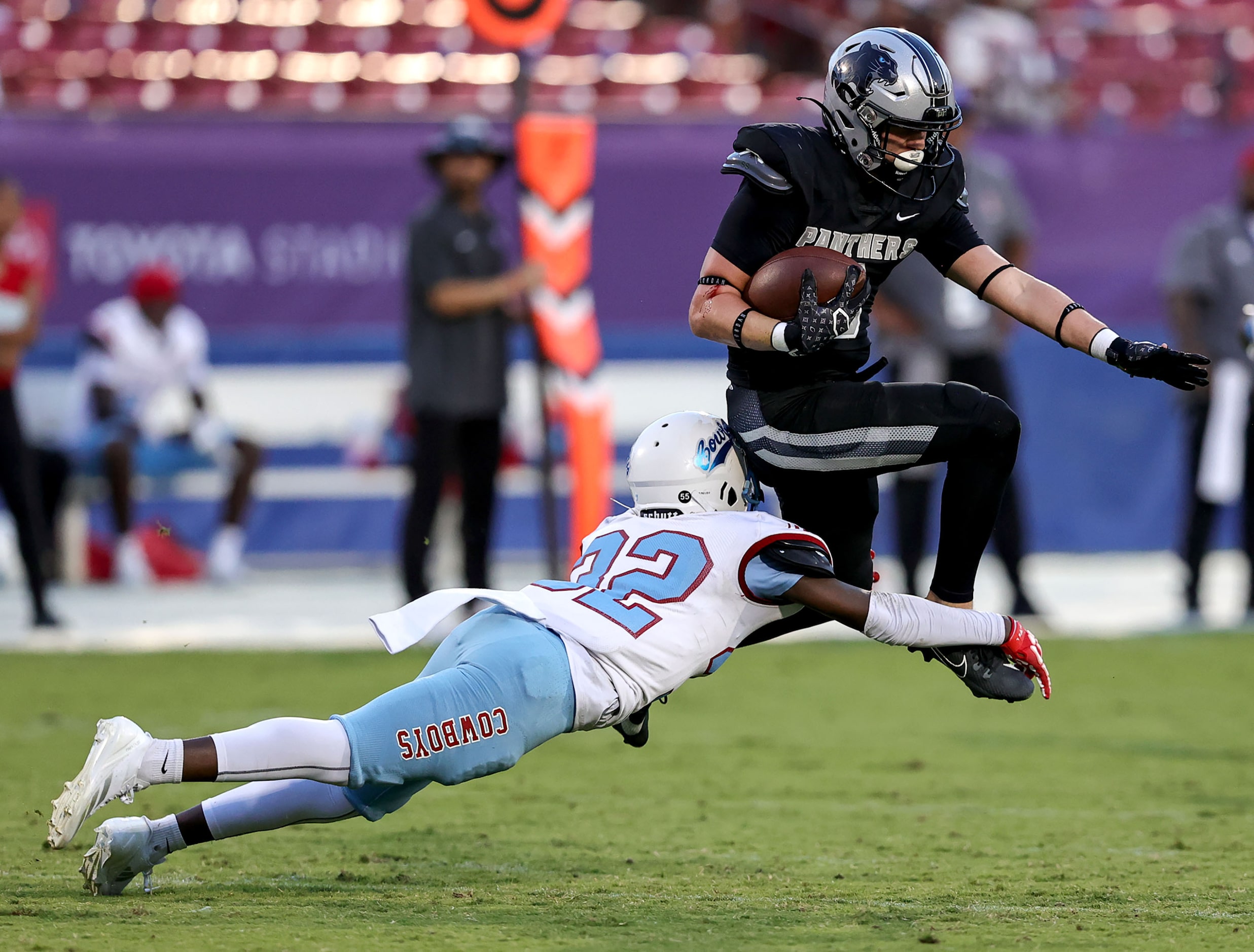 Frisco Panther Creek running back Seth Jackson (R) tries to leap over Dallas Carter...