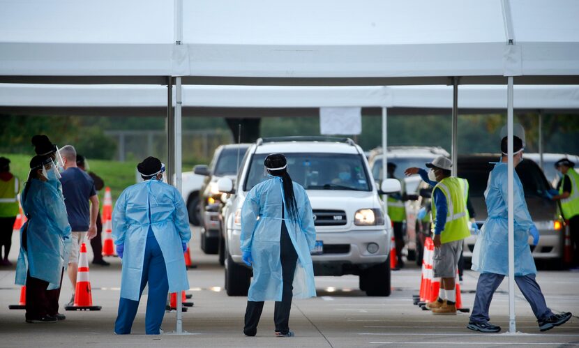 Medical personnel prep and conducted nasal swab tests at a drive-through COVID-19 testing...