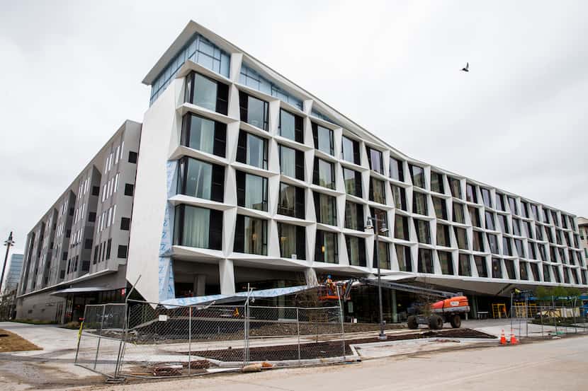 Construction workers put finishing touches on the exterior of the AC Hotel, which is under...