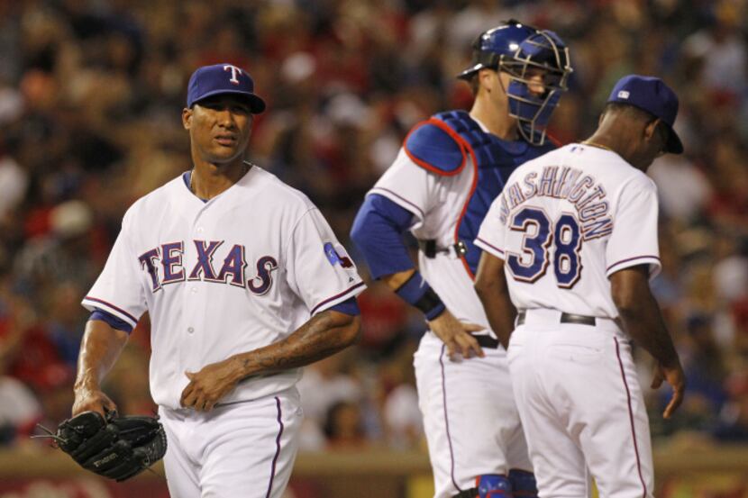 Texas Rangers starting pitcher Alexi Ogando (41) walks off the mound after being pulled by...