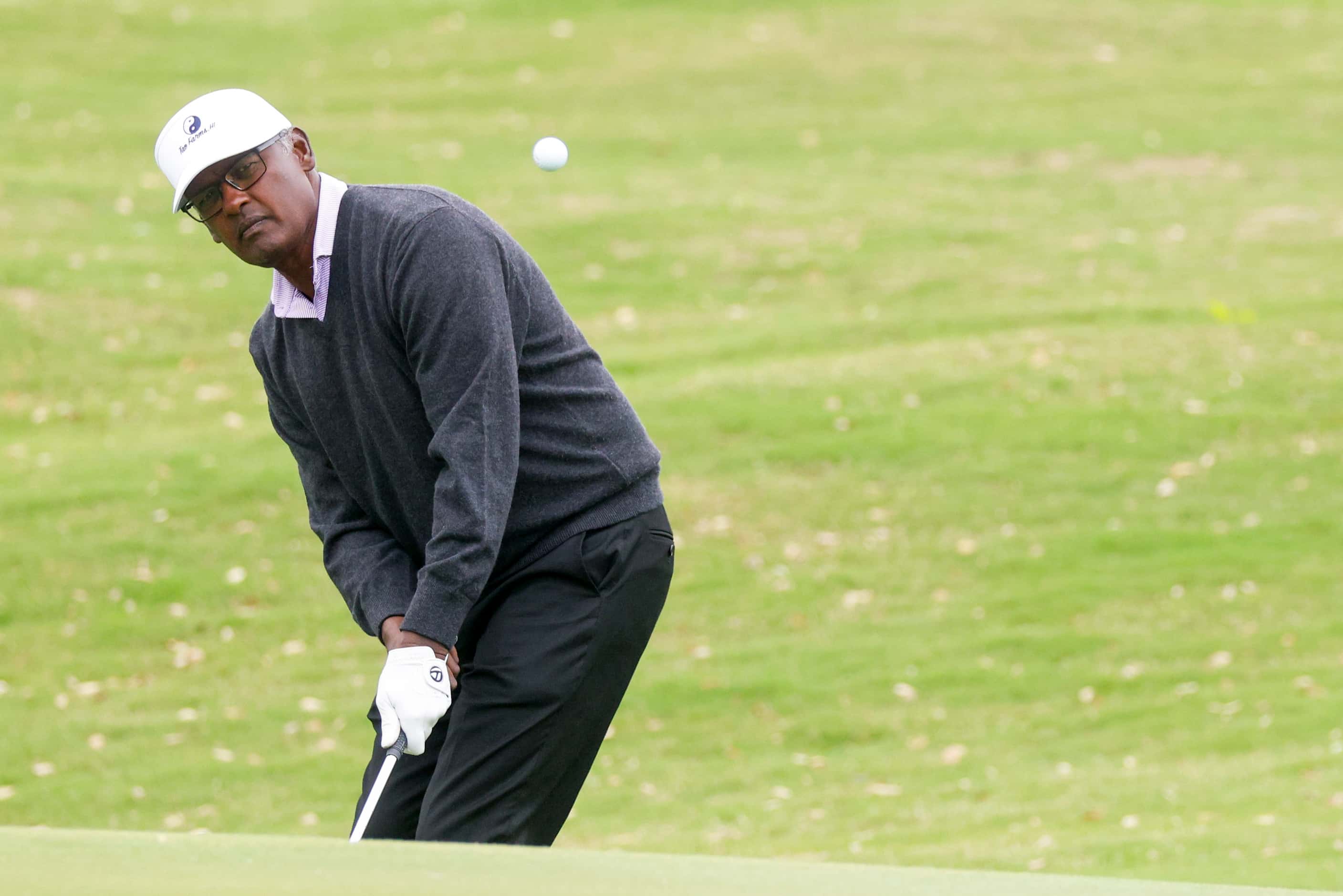 Professional golfer Vijay Singh chips his ball onto the 9th green during the first round of...