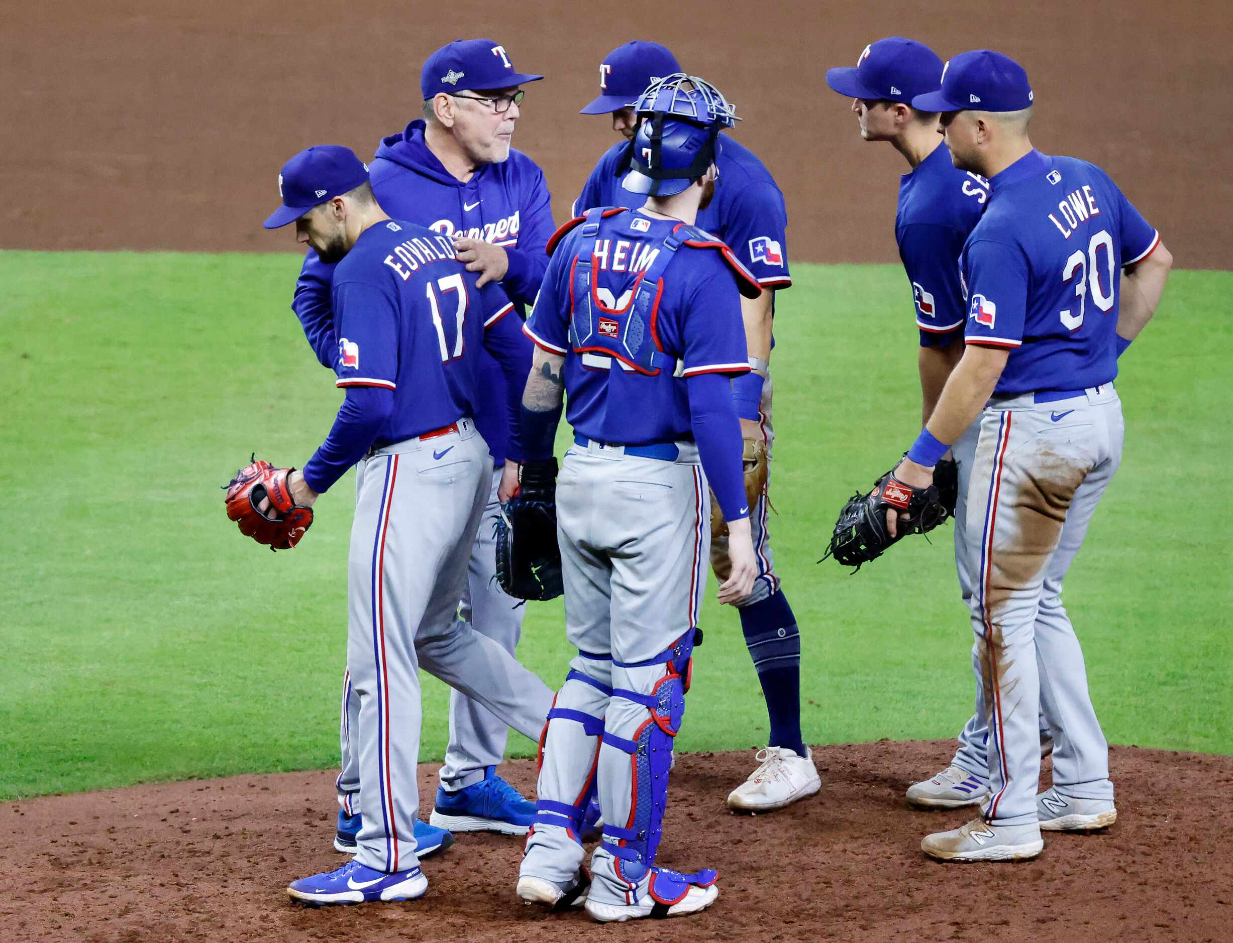 Texas Rangers manager Bruce Bochy (second from left) pats starting pitcher Nathan Eovaldi...