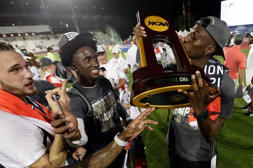 Texas Tech's Justin Hall kisses the trophy as he celebrates with teammates after they won...