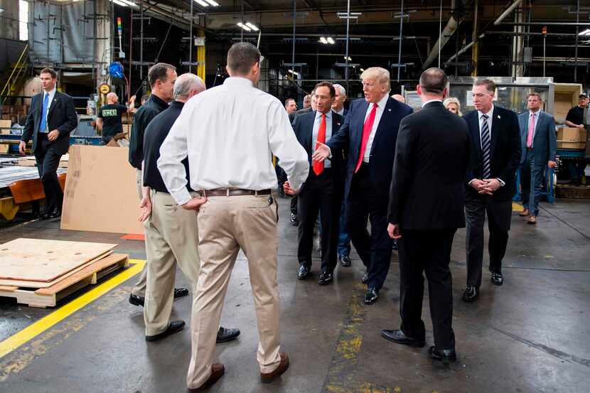 US President Donald Trump reached out to shake hands as he tours The Ames Companies, Inc.,...