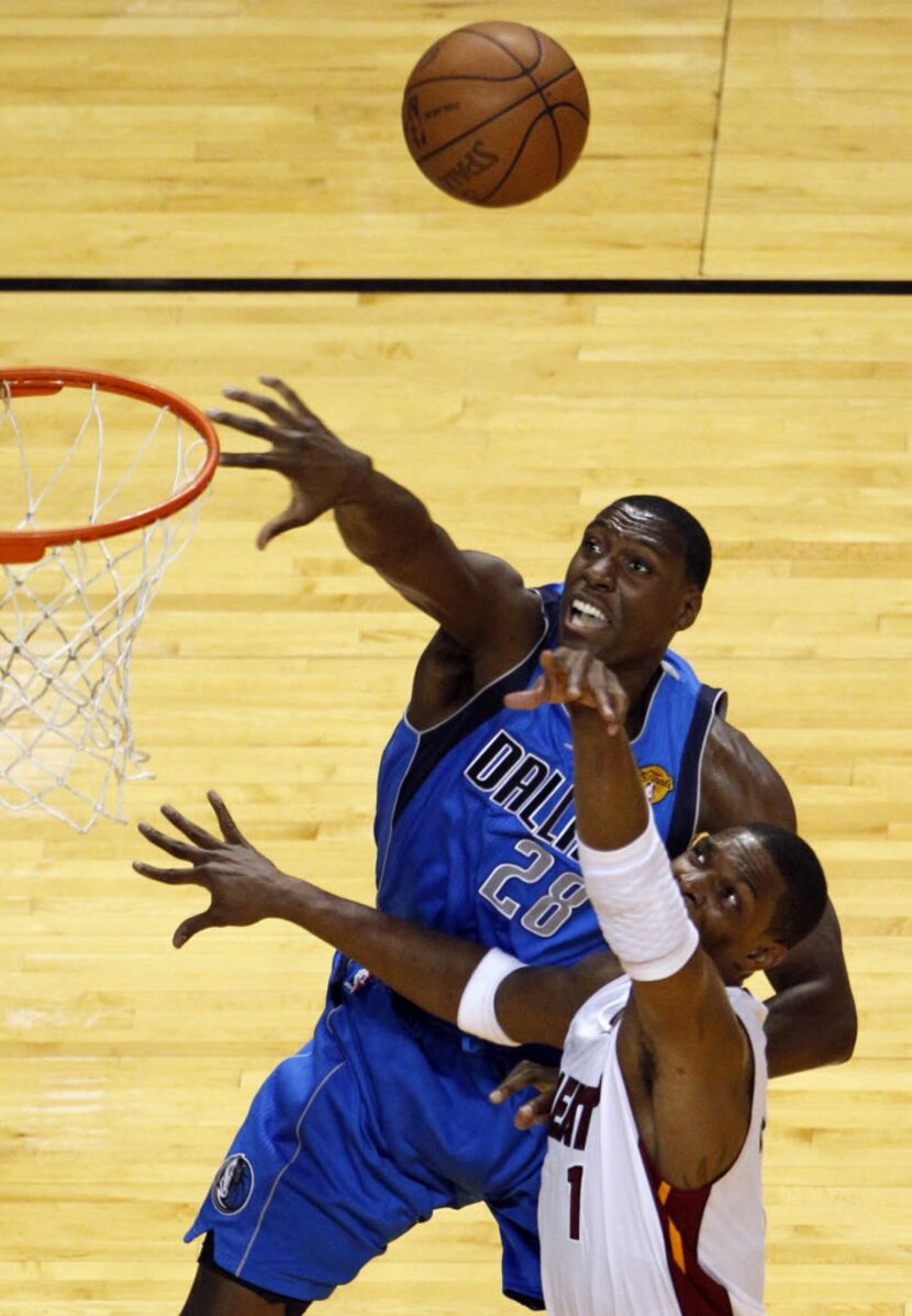 Dallas Mavericks center Ian Mahinmi (28) and Miami Heat power forward Chris Bosh (1) go...