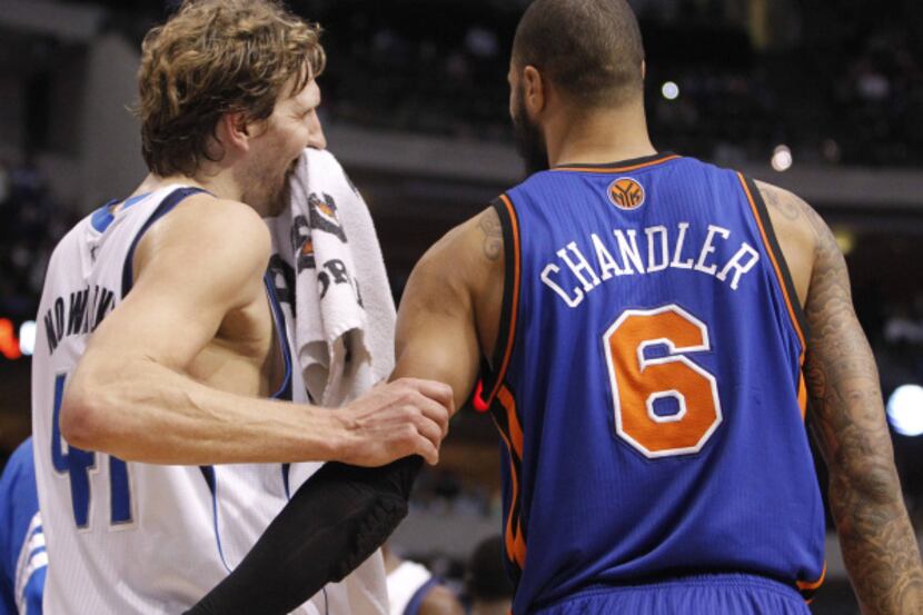Dallas' Dirk Nowitzki (41) and former teammate Tyson Chandler share a light moment near the...