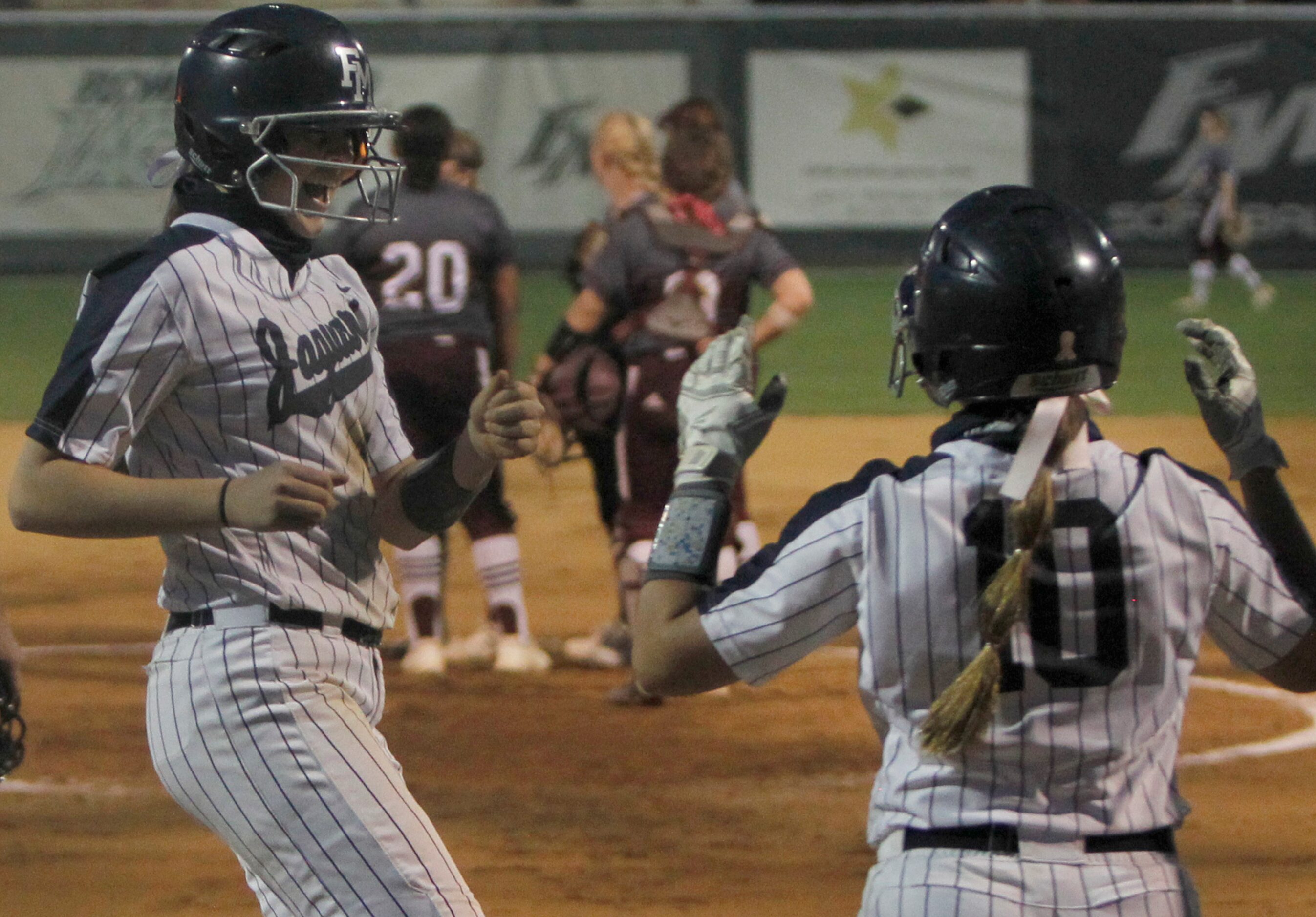 Flower Mound 1st baseman Jordyn Holland (18), left, was all smiles as she celebrates with...