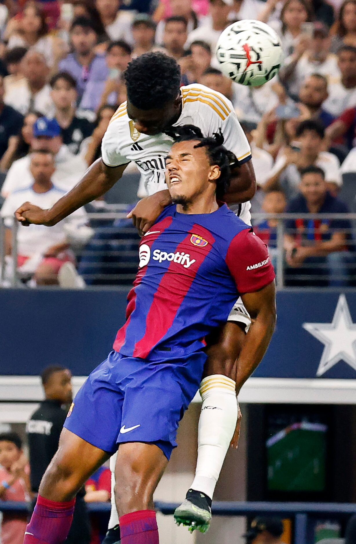 Real Madrid midfielder Aurélien Tchouaméni (18) goes above Barcelona defender Jules Koundé...