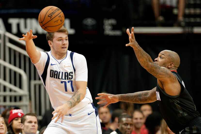 Dallas Mavericks forward Luka Doncic (77) passes the ball around Houston Rockets forward PJ...