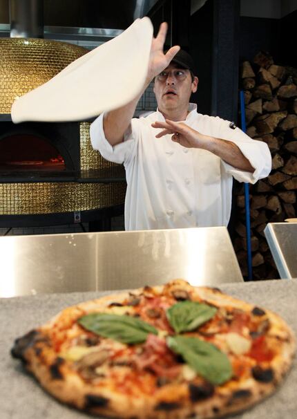 The gold oven sits behind pizzaiolo Stefano Leardini.