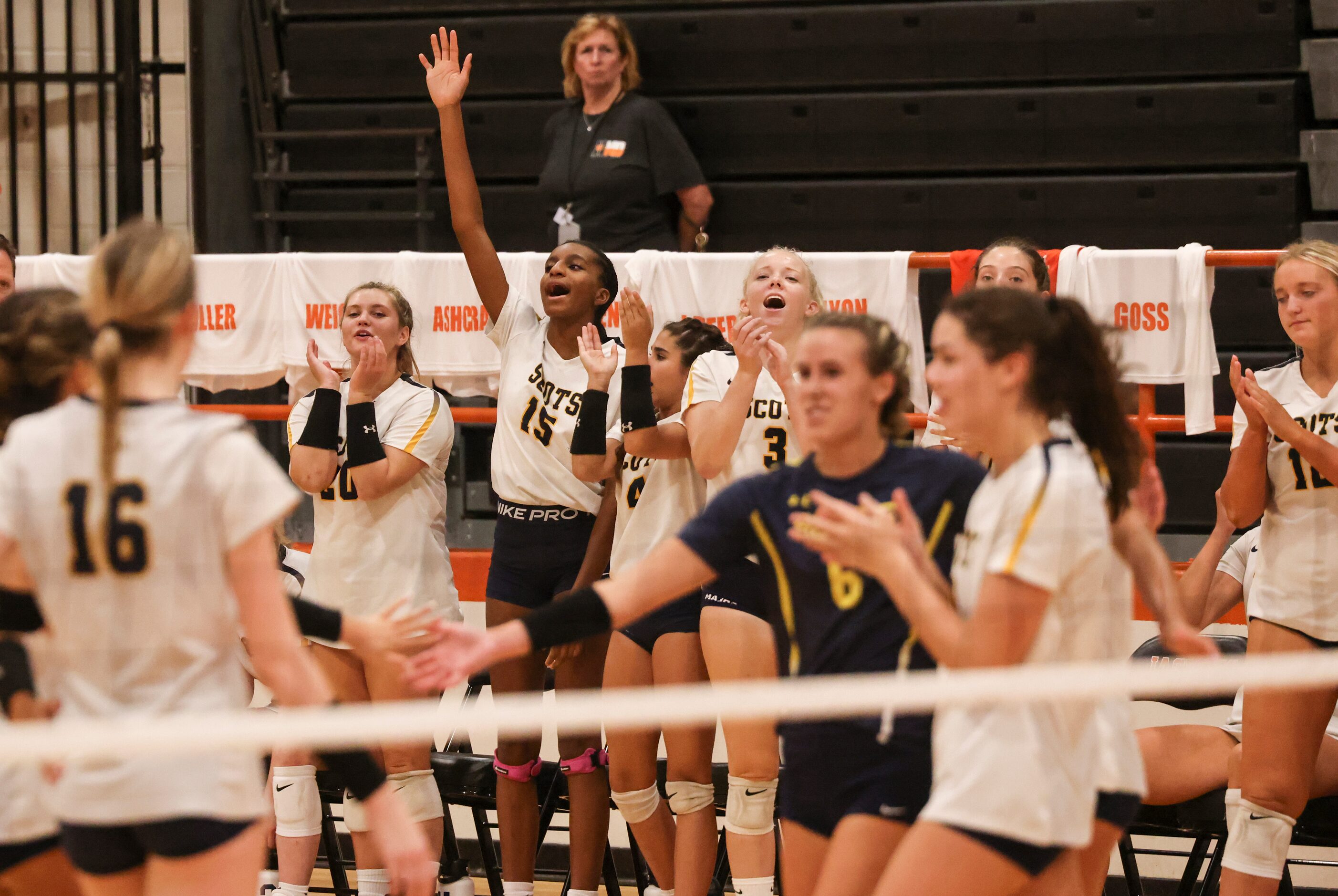 Highland Park High School bench players react as the team wins the volley during the...