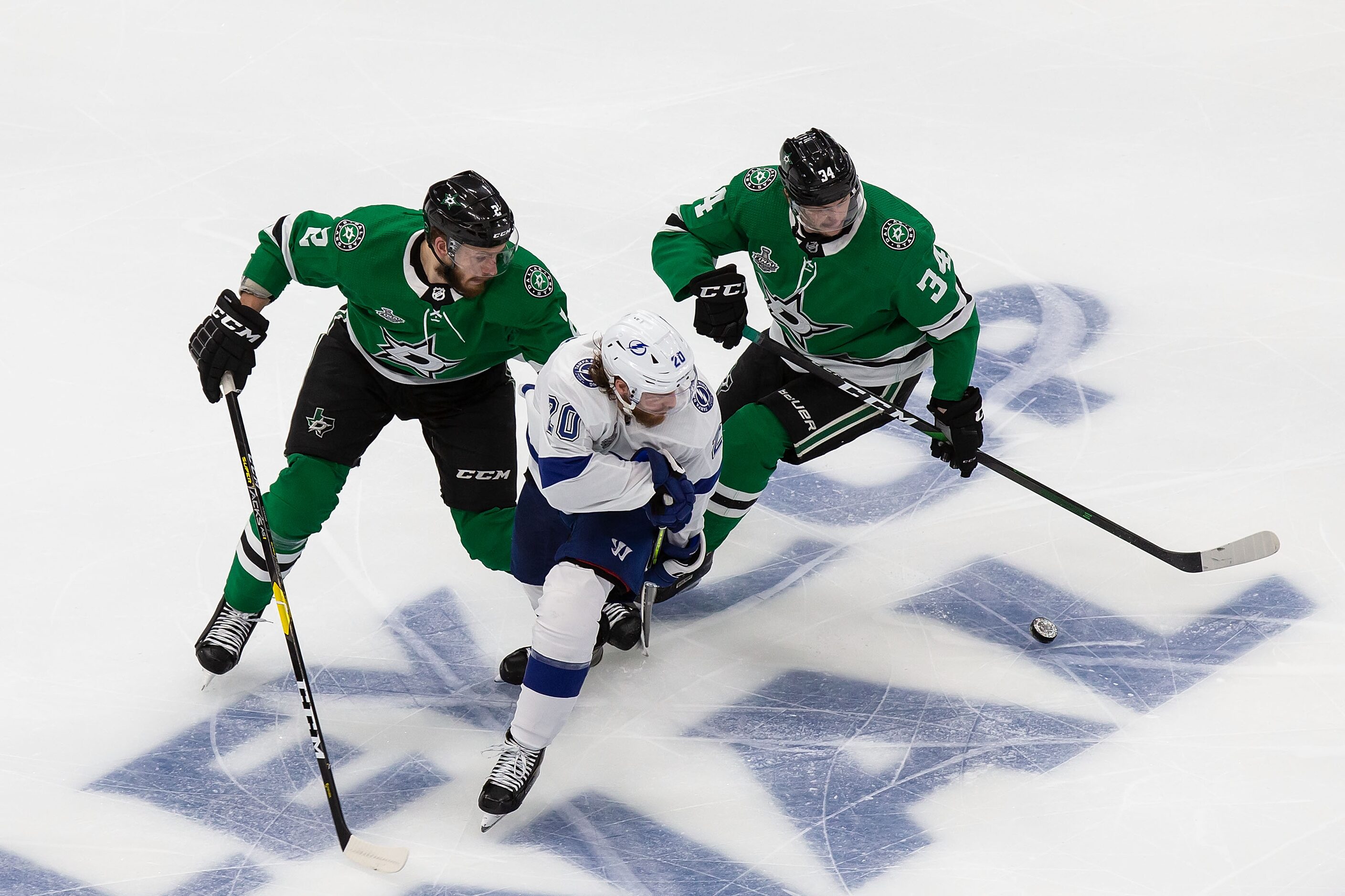 Jamie Oleksiak (2) and Denis Gurianov (34) of the Dallas Stars pursue Blake Coleman (20) of...