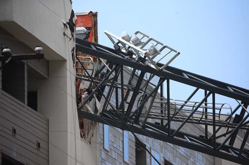 Officials respond to the scene after a crane collapsed into Elan City Lights apartments in...