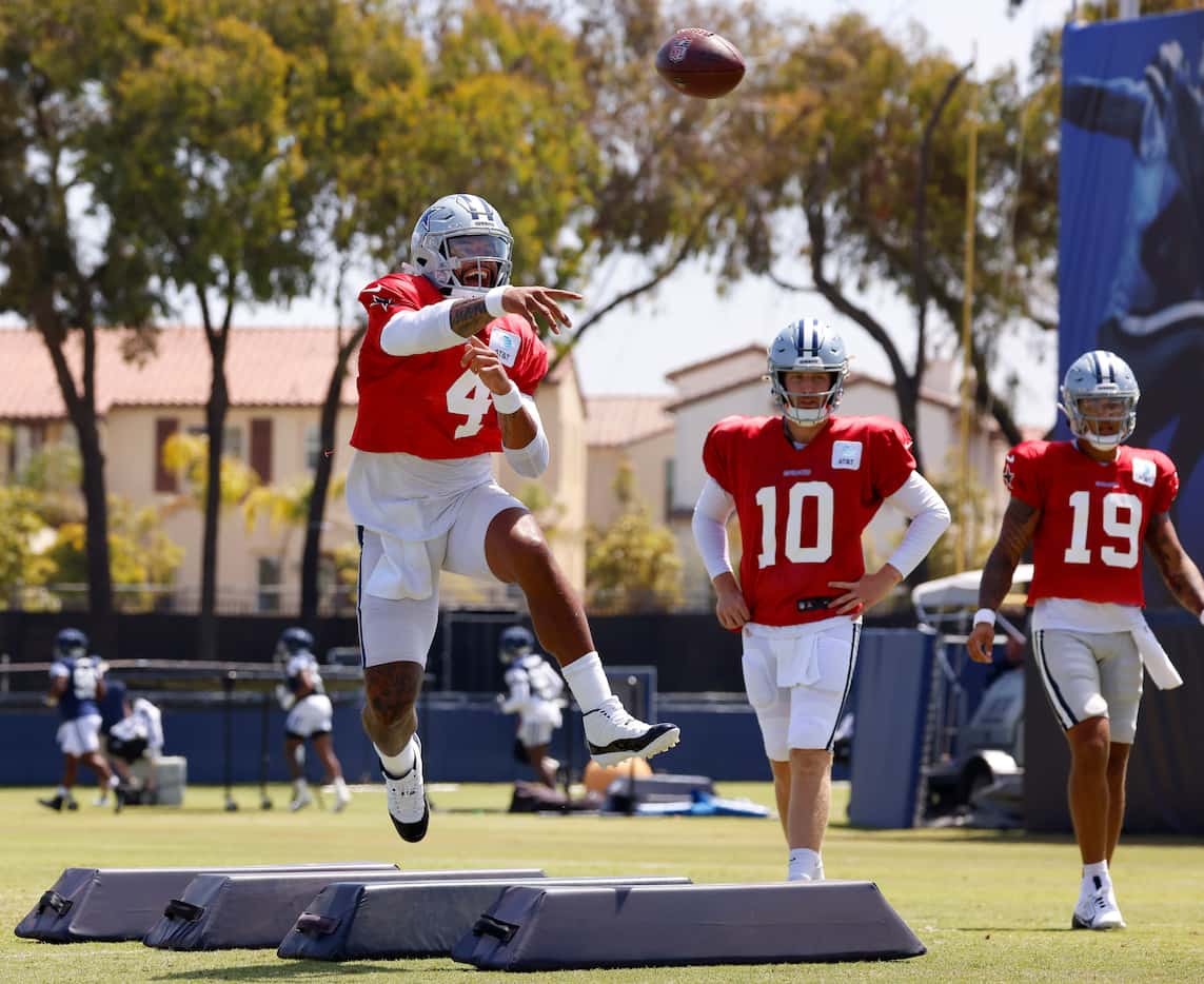 Dallas Cowboys quarterback Dak Prescott (4) throws on the run at a target during training...