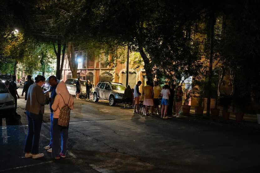 Personas se congregan en una calle de la Ciudad de México la madrugada del jueves 22 de...