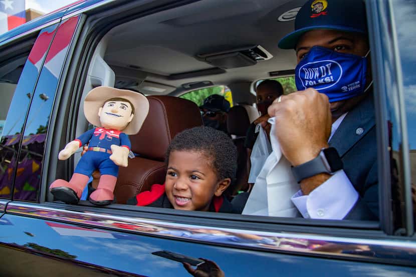 Dallas Mayor Eric Johnson and son George waited for their Fletcher's Corny Dogs during the...